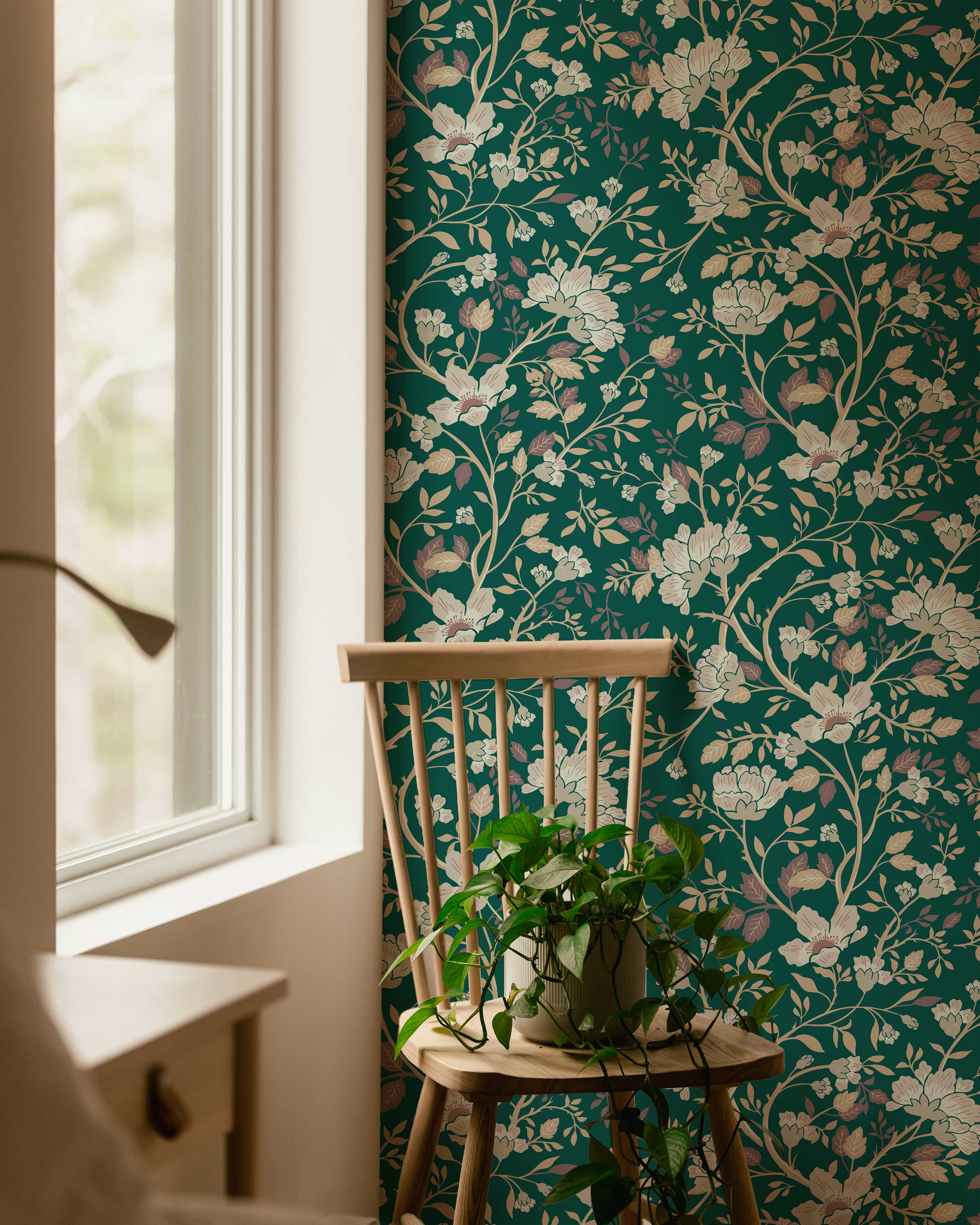 Floral wallpaper with a chair and plant in a room with a window.