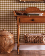 Wooden side table with wicker basket and jar against a green checkered wall.
