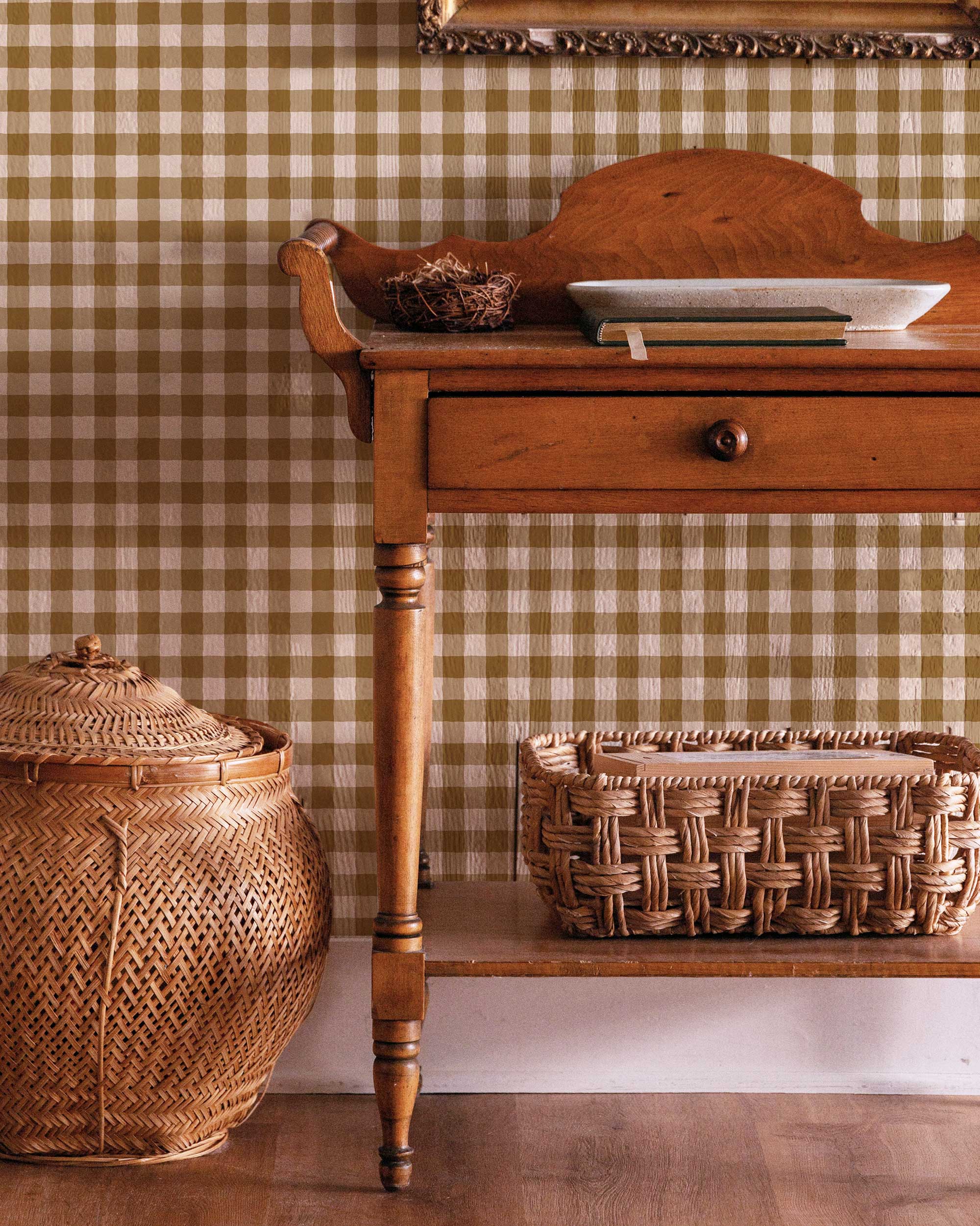 Wooden side table with wicker basket and jar against a green checkered wall.