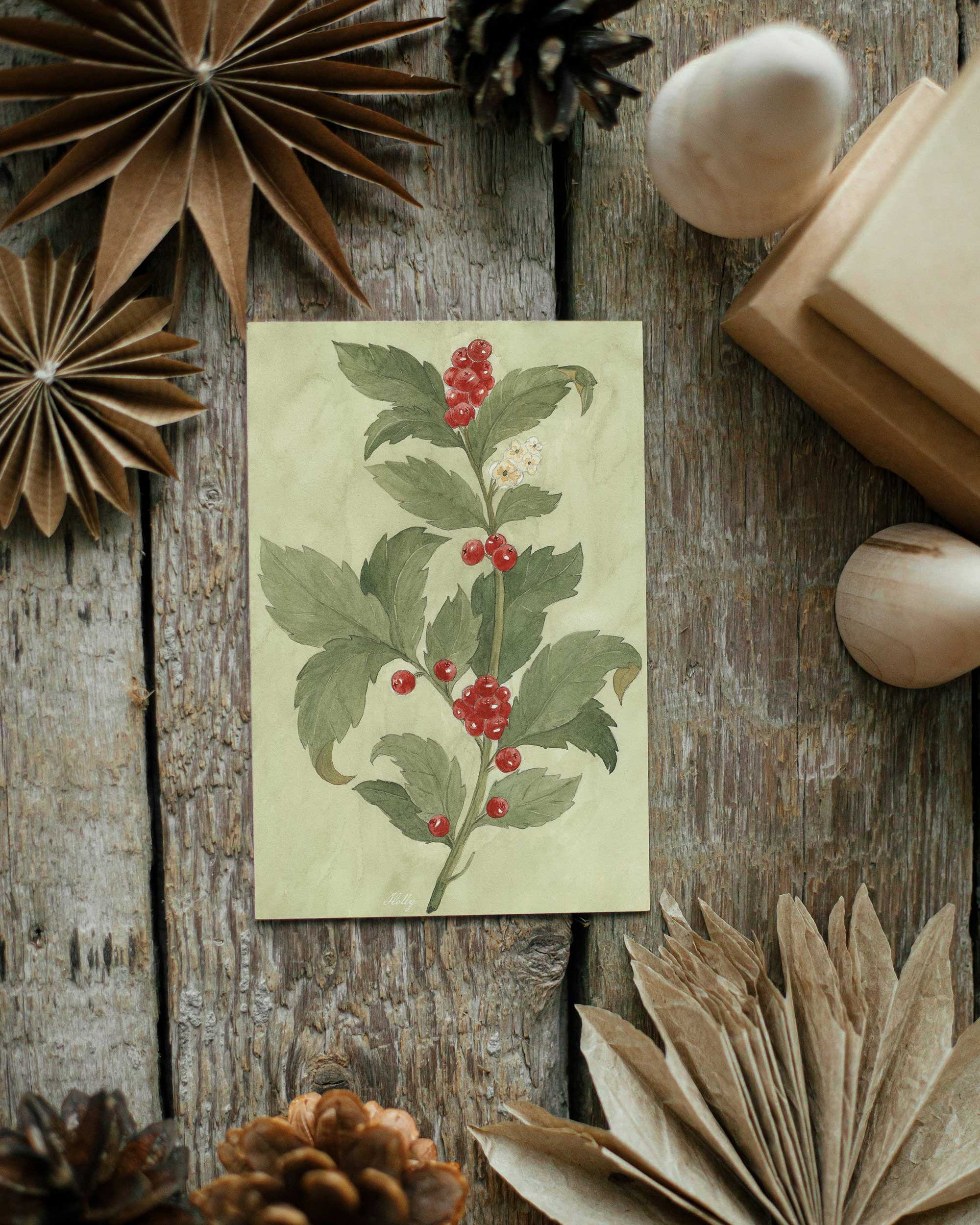 Card with botanical design surrounded by decorative elements on a wooden surface