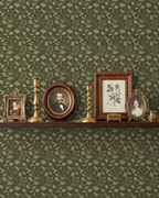 Wild Geranium wallpaper in earthy olive with floral motifs and vintage decor on shelf.